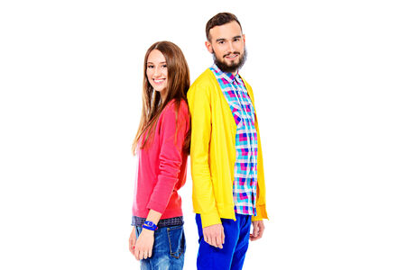 Two modern young people standing together and smiling. Isolated over white.の写真素材