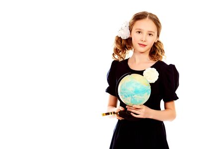 Portrait of a ten years schoolgirl uniform holding a globe. Isolated over white.の写真素材