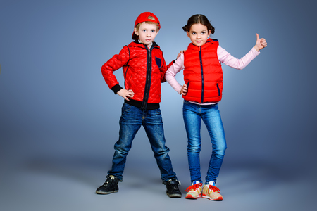 Full length portrait of modern boy and girl standing together. Fashion. の写真素材