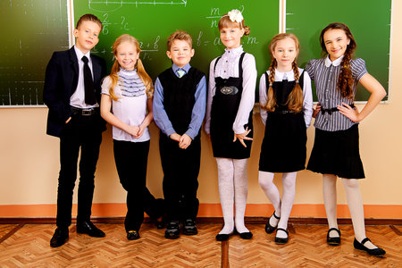 Happy schoolchildren at a classroom. Education.