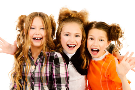Three happy girls standing together and laughing. Isolated over white.の写真素材