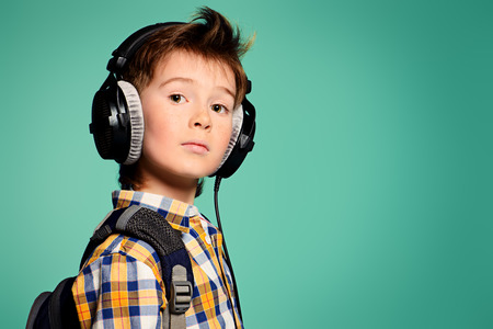 Cute 7 year old boy listening to music on headphones. Copy space.の写真素材