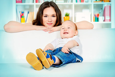Beautiful young mother with her little baby at home.