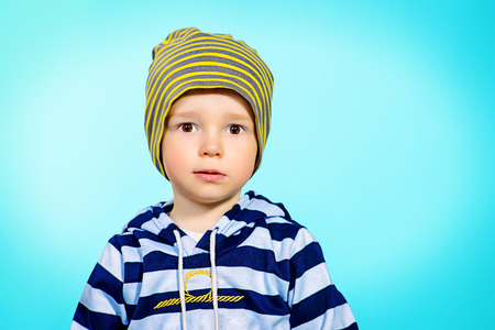 Portrait of a cute 2 years old boy over blue background. Childhood.の写真素材