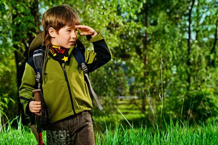 Portrait of a cute 7 years old boy in tourist clothes posing outdoor. Summer day. の写真素材