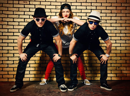 Group of young modern people posing together with fun. Urban lifestyle. Hip-hop generation.