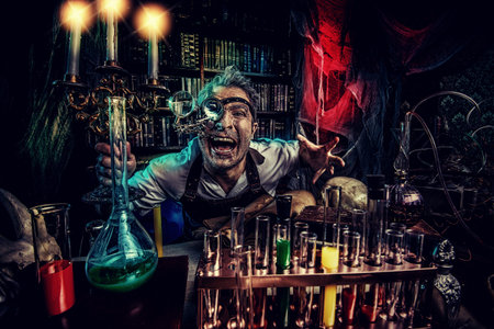 Portrait of a crazy medieval scientist working in his laboratory. Alchemist. Halloween.の写真素材