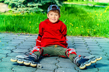 Cool 7 year old boy rollerblades on the street. Childhood. Summertime.の写真素材