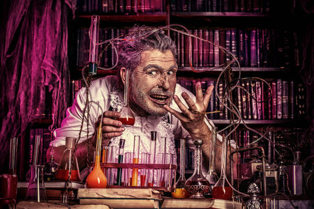 Crazy old man medieval scientist working in his laboratory. Alchemist. Halloween.の写真素材