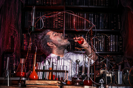 Crazy old man medieval scientist working in his laboratory. Alchemist. Halloween.の写真素材