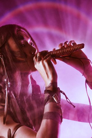 Portrait of the American Indian playing flute. Ethnicity and history. Art project.の写真素材
