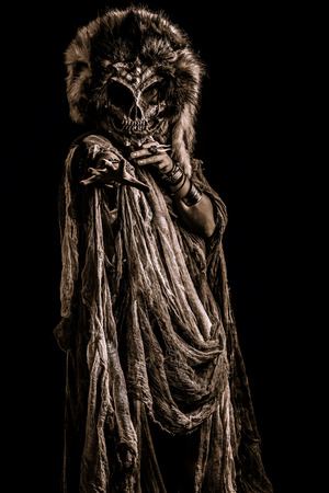 Frightening female wearing mask of skull. Fantasy. Halloween. Witchcraft, voodoo dances.の写真素材