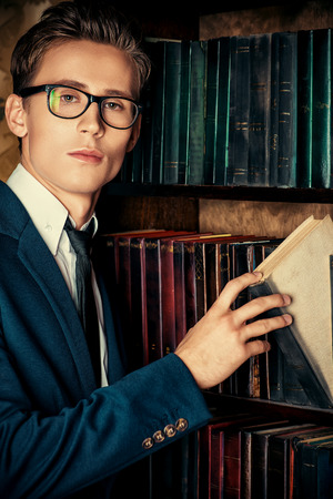 Close-up portrait of a respectable handsome man in his cabinet, library. Classic vintage style.の写真素材