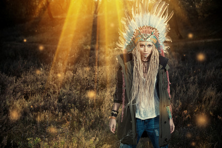 Fashion shot of a beautiful girl in style of the American Indians. Western style. Jeans fashion.の写真素材