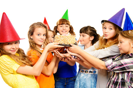 Group of happy kids celebrating birthday with a cake. Isolated over white.