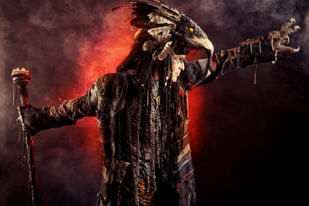 Portrait of a male shaman in ethnic dress surrounded by fog
