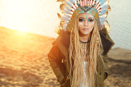 Close-up portrait of a beautiful girl wearing native american indian chief headdress. Western style....