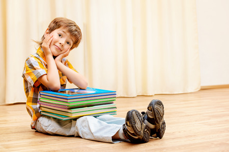 Smiling boy reading books at home.の写真素材