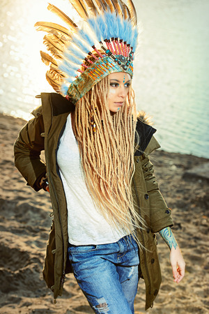 Fashion shot of a beautiful girl in style of the American Indians. Western style. Jeans fashion.の写真素材