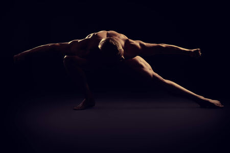 Handsome muscular athletic man posing over black background. Men's beauty. Bodybuilding. Sports.の写真素材