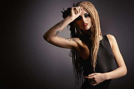 Gorgeous sexy girl with black make-up and long dreadlocks. Gothic style. Fashion. Cosmetics, hairstyle. Tattoo.の写真素材