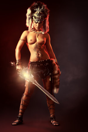 Beautiful bellicose Amazon with a sword in battle. Ancient times. Fantasy.の写真素材