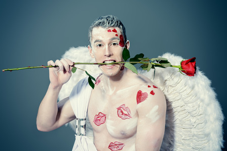 Inspired, romantic man-angel with red rose. Valentine's day. Love concept.の写真素材