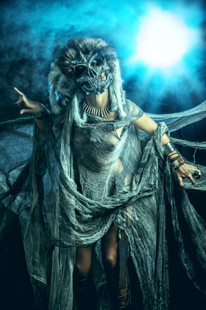 Frightening female wearing mask of skull. Fantasy. Halloween. Witchcraft, voodoo dances.の写真素材