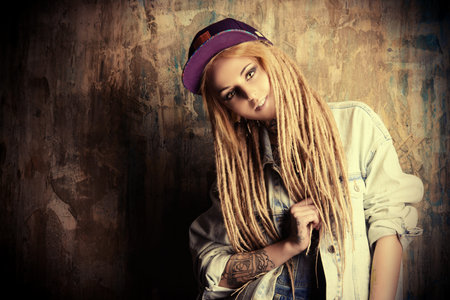 Modern teenage girl with blonde dreadlocks. Jeans style. Modern generation.
