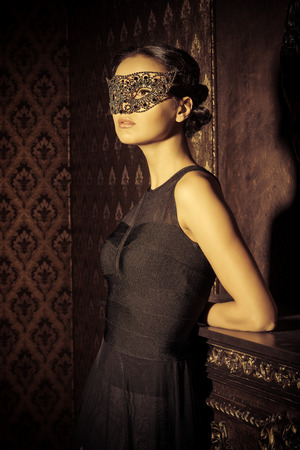 Beautiful mysterious stranger girl in venetian mask. Carnival, masquerade. Jewellery, gems.の写真素材