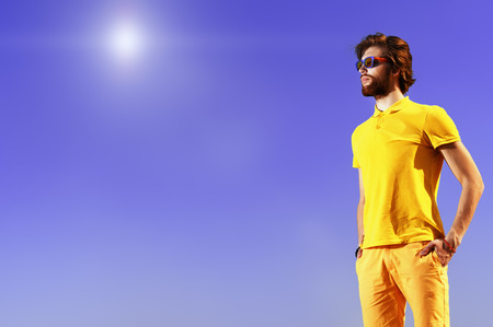 Handsome young man over blue sky. Summer rest, vacation.の写真素材