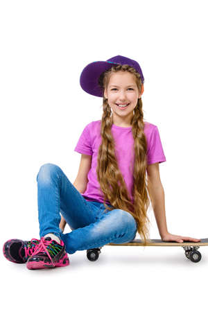 Pretty girl teenager wearing casual clothes posing with her skateboard. Active lifestyle. Studio shot. Isolated over white.の写真素材