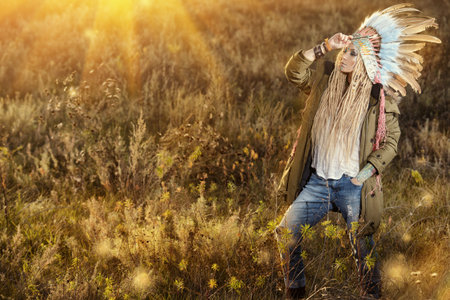 Fashion shot of a beautiful girl in style of the American Indians. Western style. Jeans fashion.