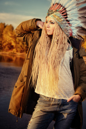 Fashion shot of a beautiful girl in style of the American Indians. Western style. Jeans fashion.の写真素材