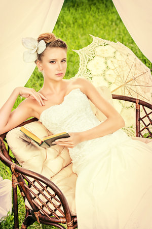 Charming elegant bride under the wedding arch. Wedding dress and accessories. Wedding decoration.の写真素材