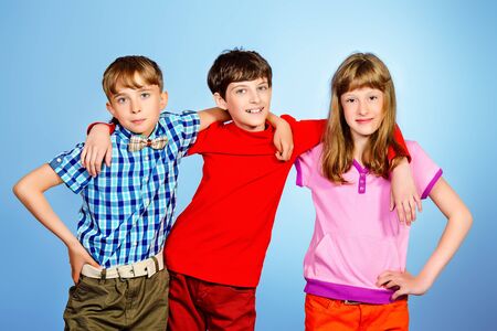 Three friends teenagers standing together. Studio shot.の写真素材