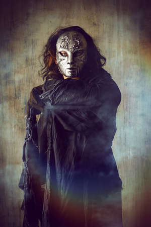 Scary man in iron mask and black robe. Fantasy. Halloween.の写真素材