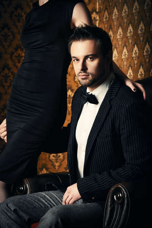 Beautiful man and woman in elegant evening clothes in classic vintage apartments. Glamour, fashion. Love concept.の写真素材
