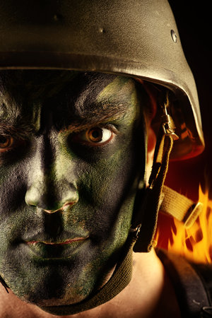 Close-up portrait of a brave soldier in war paint looking at camera.の写真素材