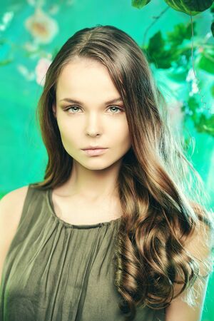 Beautiful young woman  among tropical plants and flowers. Beauty, fashion. Spa, healthcare.の写真素材