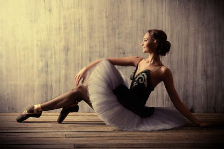 Professional ballet dancer posing at studio over grunge background. Art concept.の写真素材
