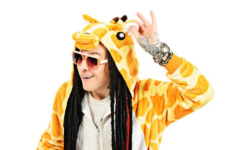 Rock musician in a costume of giraffe dancing and singing at studio. Zoo party. Entertainment, rock show. Isolated over white.の写真素材