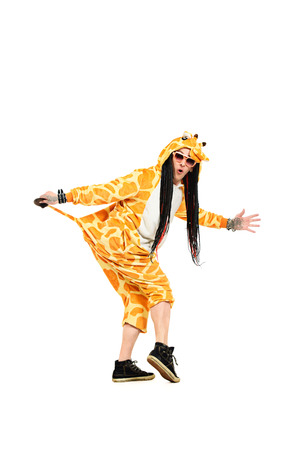 Rock musician in a costume of giraffe dancing and singing at studio. Zoo party. Entertainment, rock show. Isolated over white.の写真素材