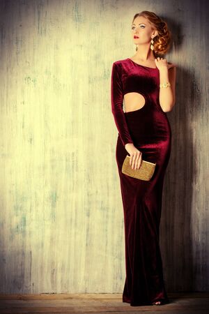 Charming young woman wearing elegant evening dress and beautiful hairstyle. Jewellery.  Fashion shot. Full length portrait.の写真素材