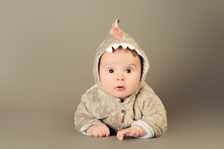 Beautiful little baby lying on a floor. Kid's fashion. Happy childhood. Studio shot.