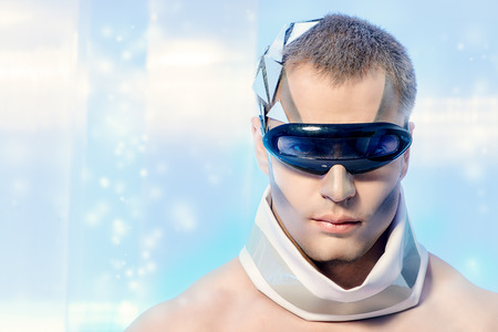 Close-up portrait of a handsome man with futuristic make-up and hairstyle standing on a luminous transparent background.の写真素材