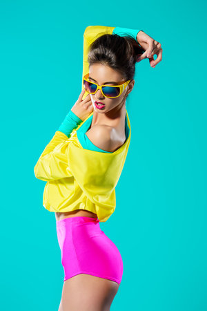 Expressive fashion model posing in vivid colourful clothes. Bright fashion. Optics, eyewear. Studio shot.の写真素材