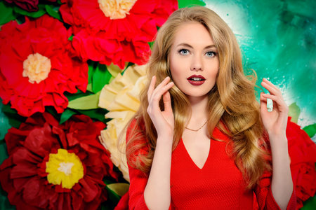 Beautiful joyful young woman with magnificent blonde hair posing on a background of bright large...