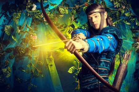 Portrait of a male elf with a bow and arrows in a magical forest.の写真素材