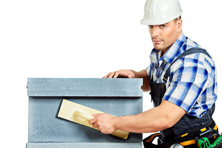 Male builder in working clothes, helmet and tools. Isolated over white.の写真素材